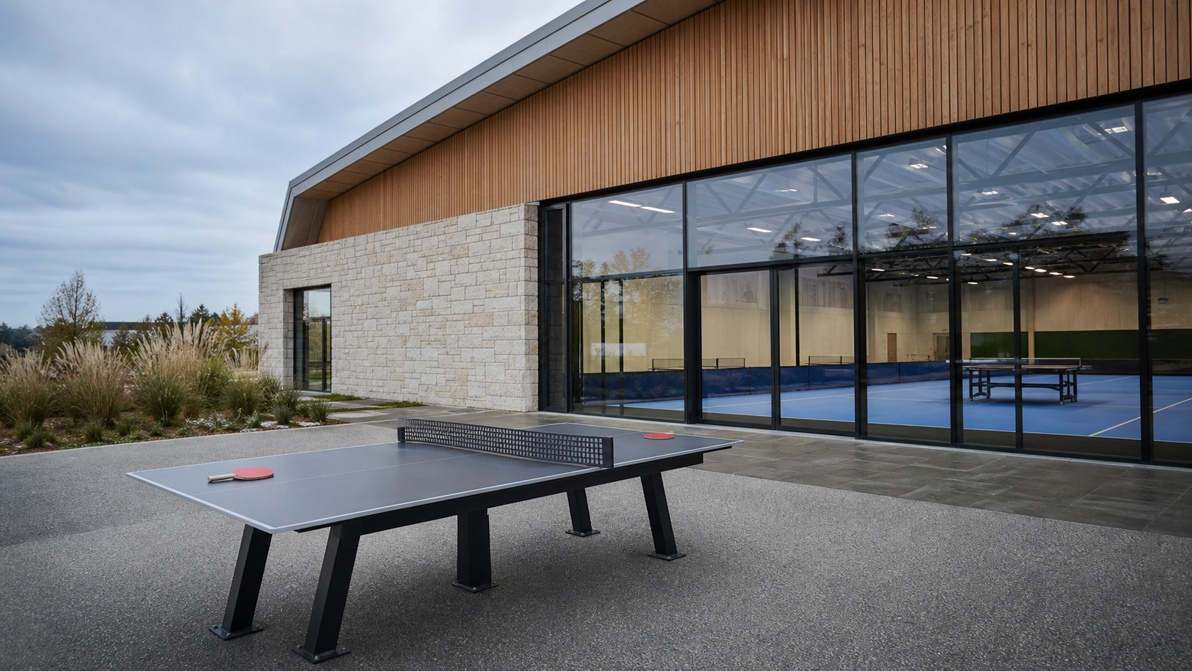 Salle sportive moderne à Lesneven avec table de tennis de table au premier plan, illustrant l’hommage aux frères Lebrun